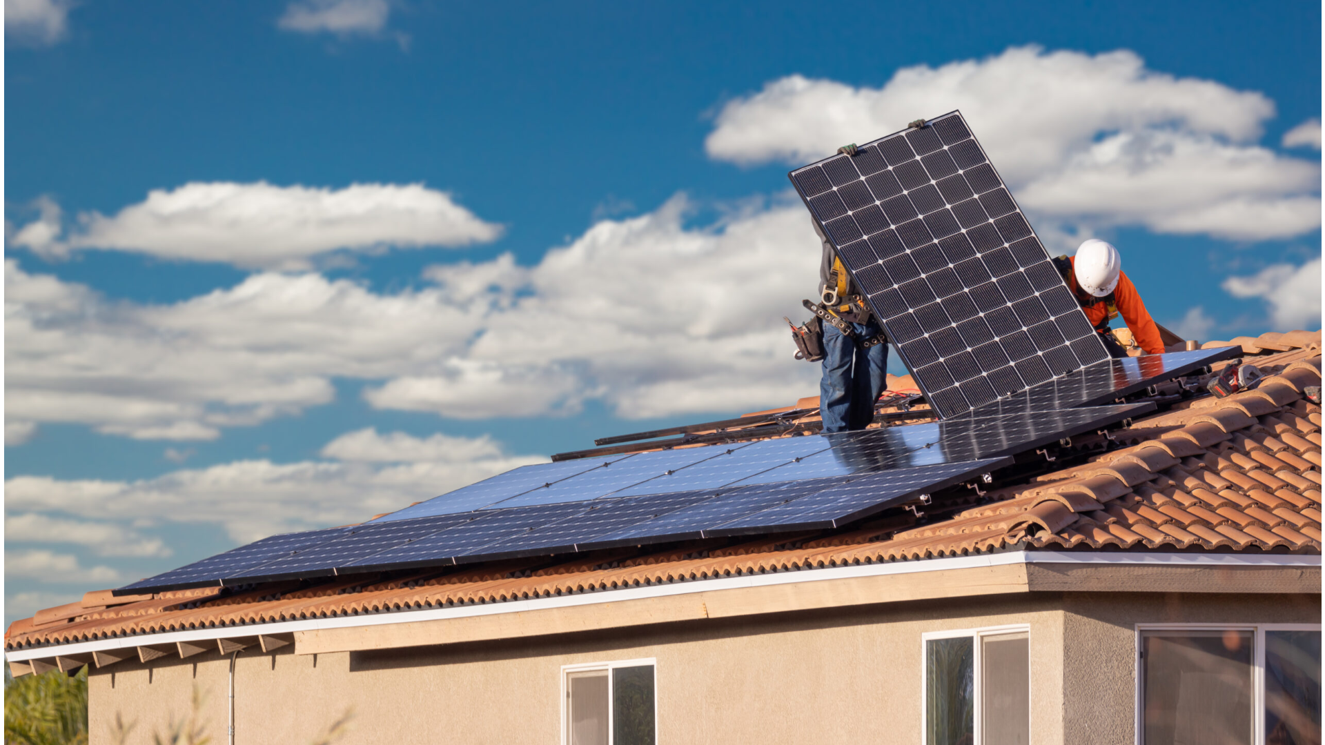 Workers Installing Solar Panels on Residential House Roof